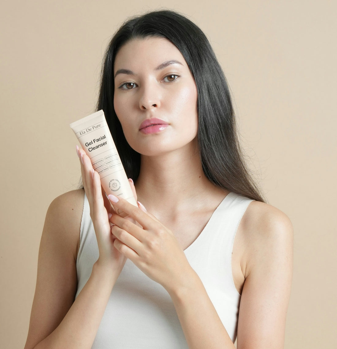 Woman holding a tube of facial cleanser